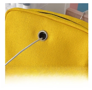 Detail of canvas bag featuring a functional metal-reinforced headphone jack on the back