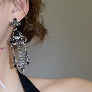 Detail of vintage silver flower earrings with black gemstones and teardrop tassels