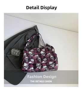 Close-up of skull and red rose pattern on canvas tote bag with adjustable silver buckle
