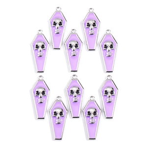 Detailed view of ten purple enamel coffin skull charms in a neat symmetrical layout