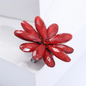 Detailed macro view of the red acrylic flower brooch petals and the metallic back pin mechanism