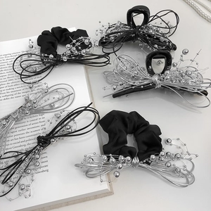 Detailed view of black bow hair claw and scrunchie with silver bead and wire accents