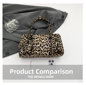 Detail view of leopard print baguette bag with heart charm and smartphone for scale