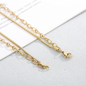 Macro detail of gold-plated snake chain with lobster clasp and adjustable extension link