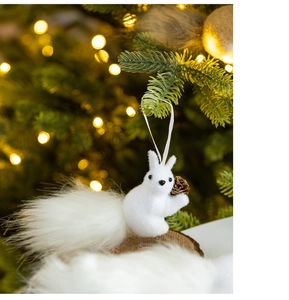 Close-up of white plush squirrel ornament holding a pinecone on a Christmas tree branch
