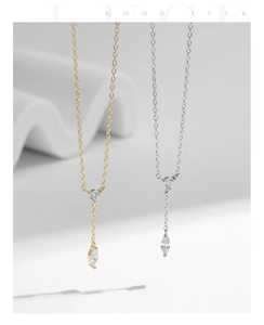 Gros plan de colliers en Y argent et or avec zircons ronds et en forme de marquise