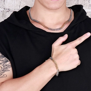 Men's two-tone gold and silver Cuban chain necklace and bracelet set worn by a model