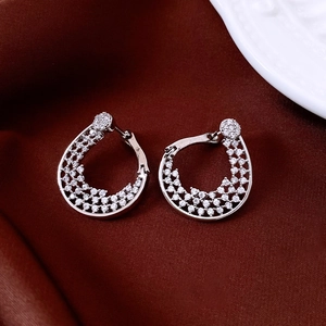 Macro detail of silver-plated flower hoop earrings with sparkling crystal pavé stones