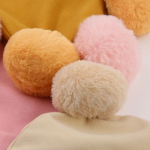 Detailed macro view of soft faux fur pom-poms in pastel colors for baby winter hats