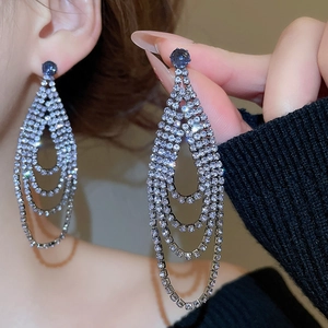 Macro shot of silver tassel earrings with sparkling blue zircons and tiered diamond dangles