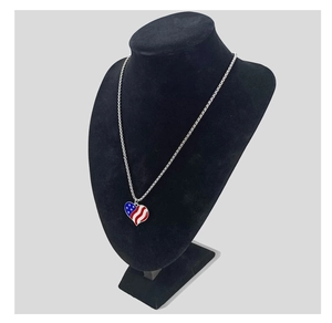 Detail of a stainless steel necklace with American flag heart pendant on a black mannequin