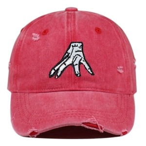Close-up of red washed cotton baseball cap with hand embroidery and distressed details