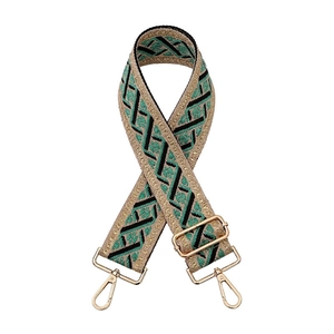Detail of adjustable woven bag strap with ethnic geometric patterns and gold lobster clasps