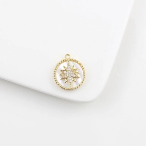 Close-up of 18k gold starburst pendant with white mother of pearl and zircon stones