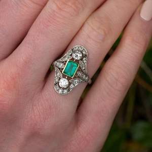 Macro view of vintage emerald ring featuring intricate hollow lace patterns and zircon