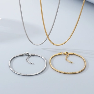 Detail view of gold and silver snake chain necklaces and bracelets with lobster clasps