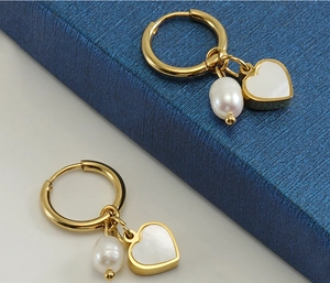 Detail of 18K gold stainless steel hoop earrings with heart shell and pearl pendants