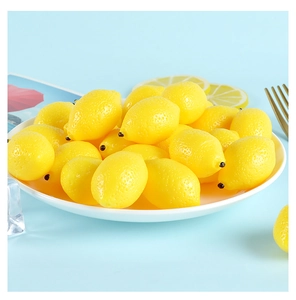 Macro shot of miniature lifelike artificial lemons on a white plate with blue background