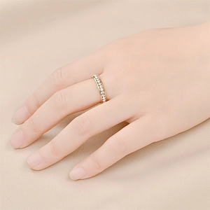 Close-up of a gold-plated titanium steel ring with sparkling crystals on a model finger