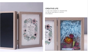 Detail of wooden shadow box frame with blue raffia and dried flowers for DIY display
