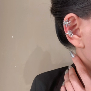 Silver snowflake ear cuff with sparkling zircon crystals on a female model's ear