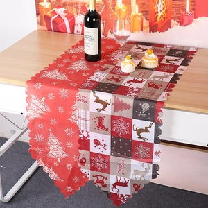 Détail du chemin de table de Noël avec motifs rennes et sapins sur une table en bois