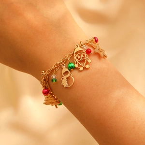 Detail of Christmas charm bracelet with Santa, snowman and snowflake on wrist