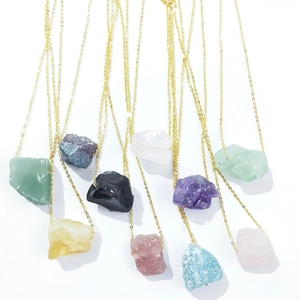 Detailed view of various natural crystal pendants with irregular shapes on gold chains