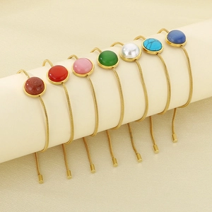 Détail de bracelets réglables en chaîne serpent dorée avec pierres précieuses rondes