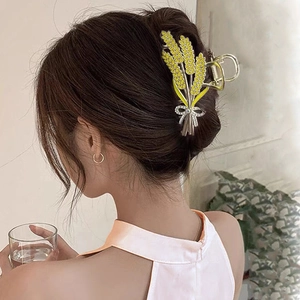 Detailed view of elegant wheat ear hair claw clip with sparkling rhinestones and silver bow