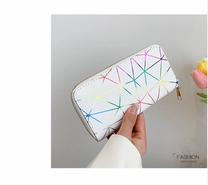 Detail of hand-held long lady's purse with white holographic geometric triangle patterns