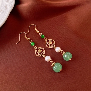 Detail of vintage flower tassel earrings with green jade beads and white pearls