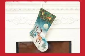 Detail of fabric Christmas stocking featuring reindeer and pine tree patterns on fireplace