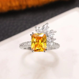 Macro detail of luxury ring with emerald cut yellow gemstone and petal shaped diamonds