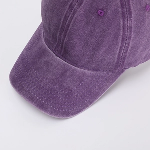 Detailed close-up showing the washed cotton texture and stitching of the purple baseball cap