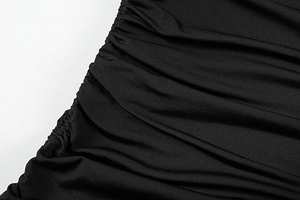 Détail d'une robe noire présentant des fronces élégantes et un cordon de serrage latéral