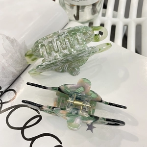 Close-up of acetic acid hair clips with marble patterns and gold metal springs