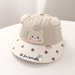 Détail du chapeau de soleil bébé avec oreilles d'ours 3D et bordure à pois marron