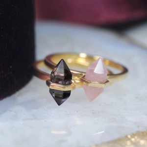 Close-up of S925 silver gold-plated rings featuring raw amethyst and rose quartz crystals