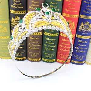 Macro detail of silver bridal crown with emerald teardrop gems and golden leaf accents