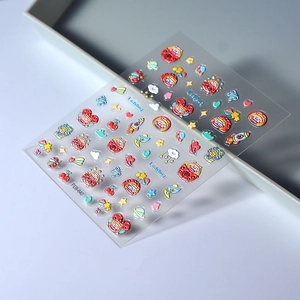 3D embossed ladybug nail stickers with cartoon rockets and stars on a grey tray