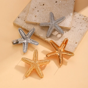 Detailed view of gold and silver starfish pendants on a textured stone surface