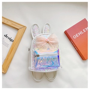 Detail of white sequin backpack featuring rabbit ears and a large pink decorative bow