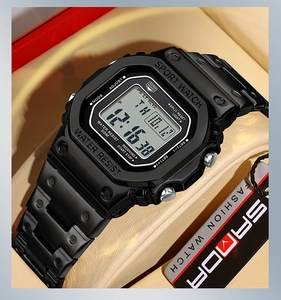 Detail of square black digital sports watch with metal strap on beige leather cushion