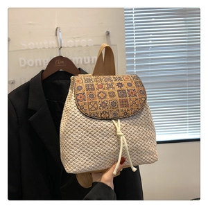 Detail of hand-woven straw bucket bag with floral geometric print flap and drawstring