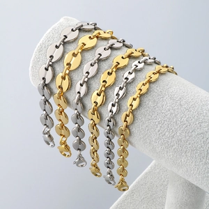 Detail of coffee bean link bracelets in gold and silver steel on a jewelry display stand