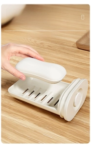 Détail d'une boîte à savon portable blanc cassé avec plateau de drainage interne sur bois
