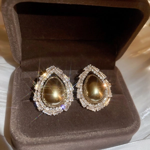 Gros plan de boucles d'oreilles perles gouttes avec zircons sur soie en coffret