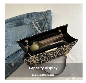 Internal view of leopard print tote bag showing multiple compartments and metal chain