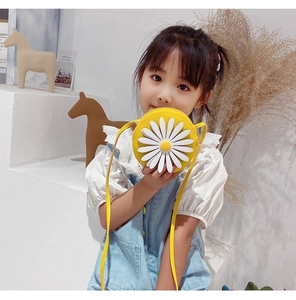 Close-up of a child's cute yellow daisy crossbody bag worn by a toddler model